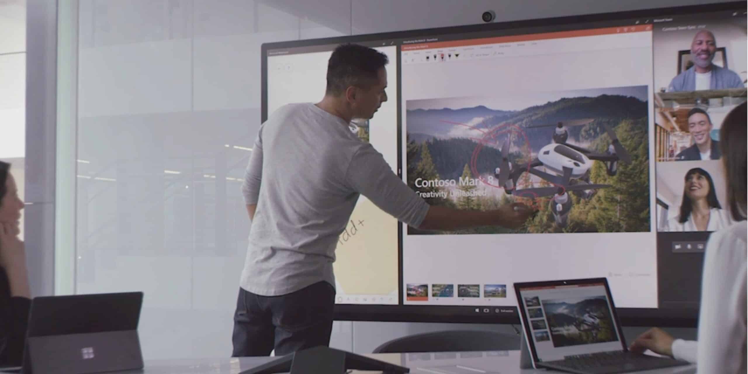 Microsoft Surface Hub 2S Whiteboard, Mann schreibt auf dem Whiteboard und nimmt gerade an einer Videokonferenz teil