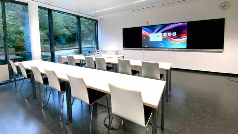 In einem modernen Seminarraum der IHK Akademie Deggendorf ist ein großes PrimeBoard-Display als zentrales Präsentationsmedium installiert, ideal für Schulungen, Business-Trainings und hybride Weiterbildungskonzepte.