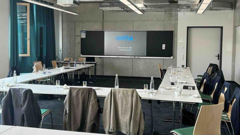 In einem modernen Schulungsraum des Gründerzentrums Landshut ist ein PrimeBoard-Display als zentrales interaktives Präsentationssystem installiert, unterstützt durch Whiteboards und Konferenztechnik für hybride Seminare und Workshops.