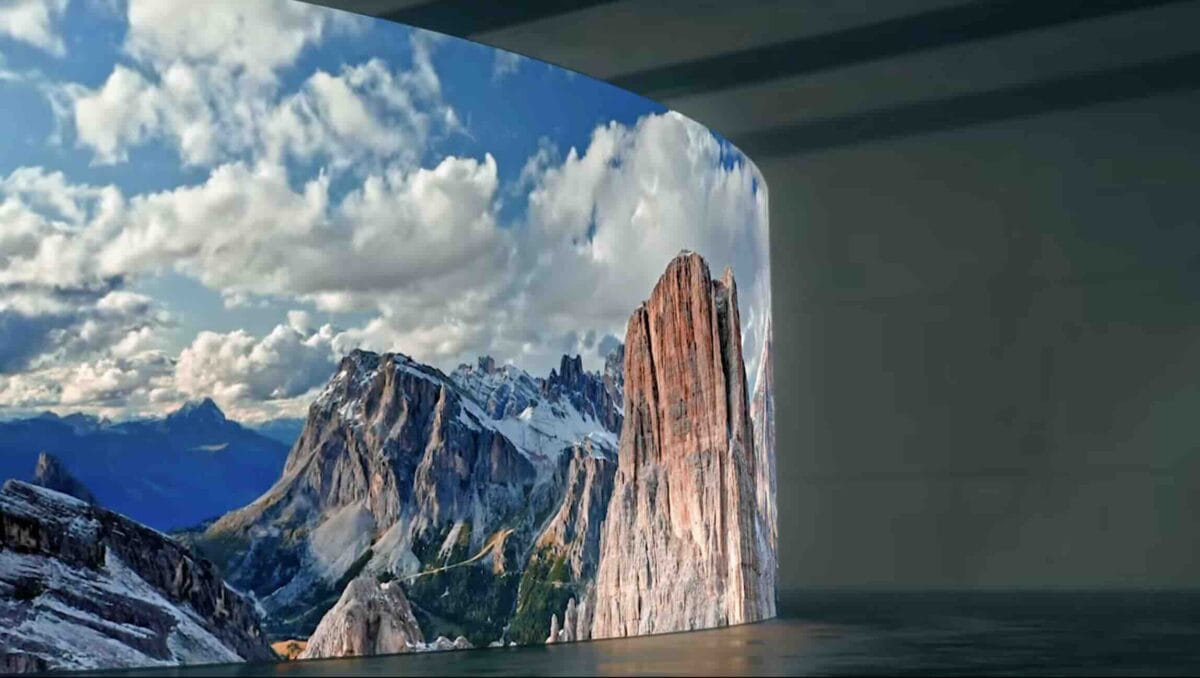 Eine gebogene Samsung LED-Wand zeigt ein gestochen scharfes Landschaftsbild der Dolomiten in einem minimalistischen Innenraum und demonstriert die hohe Farbbrillanz und Detailgenauigkeit der Displaytechnologie.