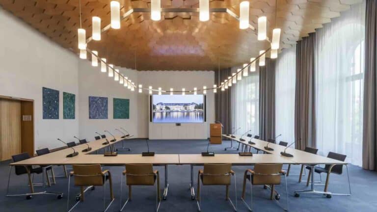 Der Sitzungssaal im Ministerium für Finanzen Baden-Württemberg in Stuttgart ist mit Fröscher-Konferenzmöbeln, einem Rednerpult und einer großflächigen LED-Medienwand ausgestattet – geeignet für Tagungen und politische Gremienarbeit.