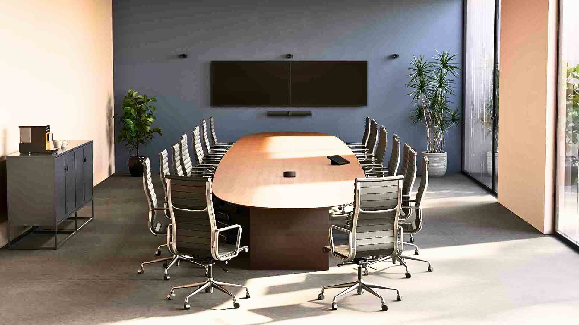 Jabra PanaCast Room Kit Multi Konferenzraum Installation Ein moderner Konferenzraum mit ovalem Holztisch, mehreren Stühlen und einem an der Wand montierten Bildschirm mit darunter platzierter Videobar ist dargestellt.