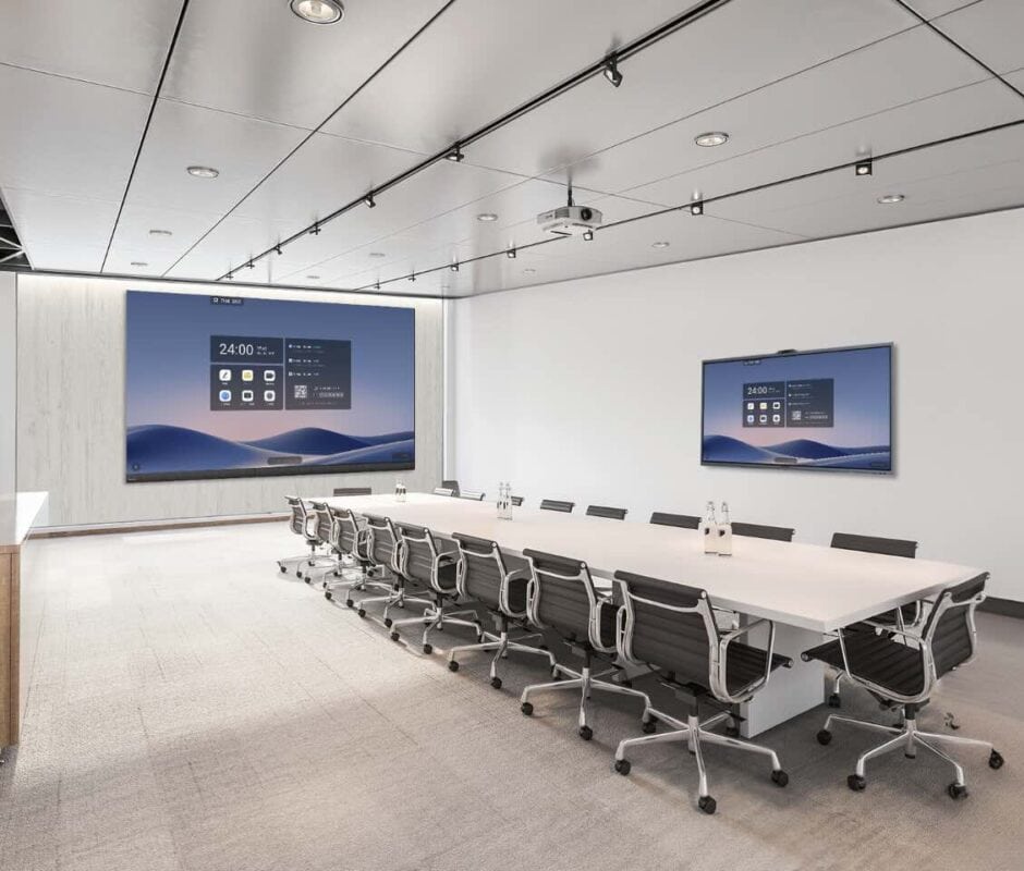 Zwei wandmontierte MAXHUB XBoard V7 Touchdisplays in einem großen, hellen Konferenzraum mit langem Besprechungstisch und mehreren Stühlen, geeignet für Präsentationen, Schulungen und hybride Meetings.