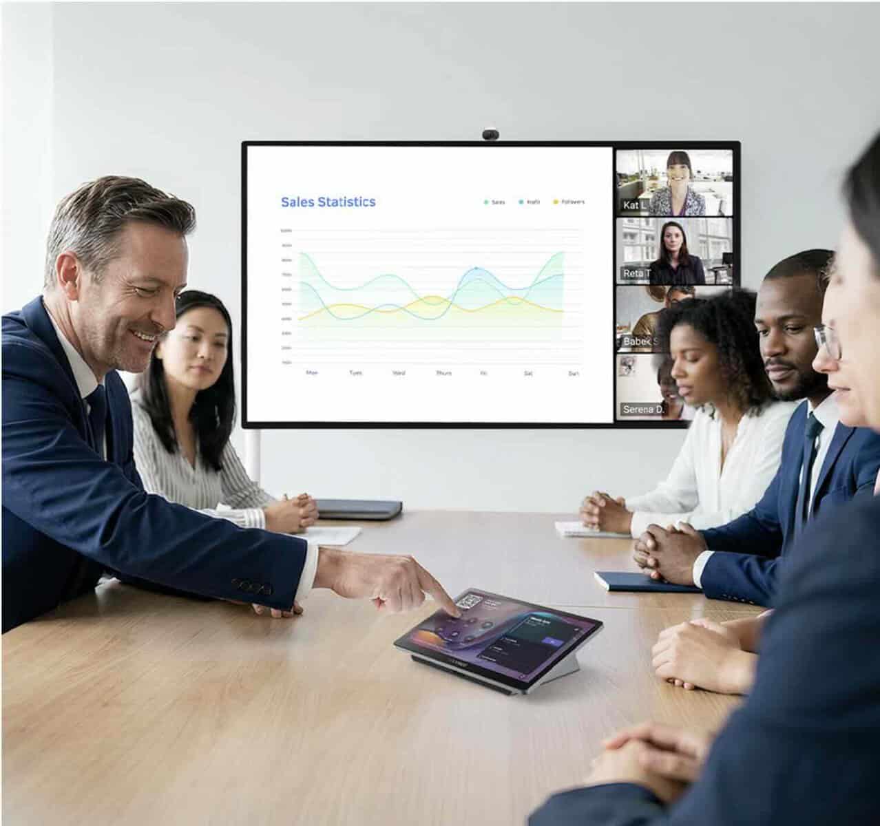 MAXHUB Universal Console TCP33T in Teams-Besprechung Eine Touch-Konsole liegt auf einem Besprechungstisch vor einem Display mit Diagramm und Microsoft-Teams-Videofenstern.