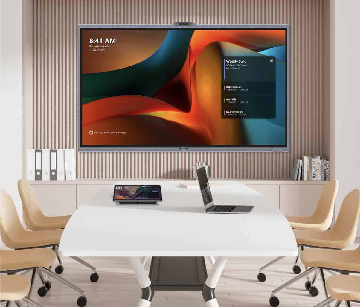 MAXHUB Universal Console TCP33T mit XBoard Eine MAXHUB Touch-Konsole liegt auf einem Konferenztisch vor einem großen Display mit Teams-Bedienoberfläche.