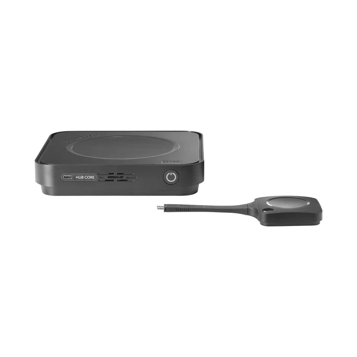 Barco ClickShare Hub Core Base Unit mit ClickShare Button Schwarze quadratische Base Unit des ClickShare Hub Core mit Power-Taste und frontseitigem USB-C-Anschluss, daneben ein ClickShare Button mit USB-C-Stecker.