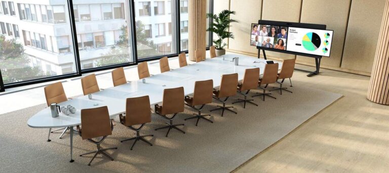 Cisco Room Kit EQX mit Dual-Display in einem Boardroom mit langem Konferenztisch – zugeschaltete Teilnehmer und eine Präsentation auf dem Bildschirm