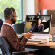 Mann im Videocall über Cisco Webex Calling – moderne Besprechungsecke im Büro