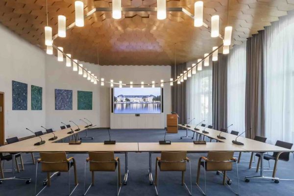 Der Sitzungssaal im Ministerium für Finanzen Baden-Württemberg in Stuttgart ist mit Fröscher-Konferenzmöbeln, einem Rednerpult und einer großflächigen LED-Medienwand ausgestattet – geeignet für Tagungen und politische Gremienarbeit.